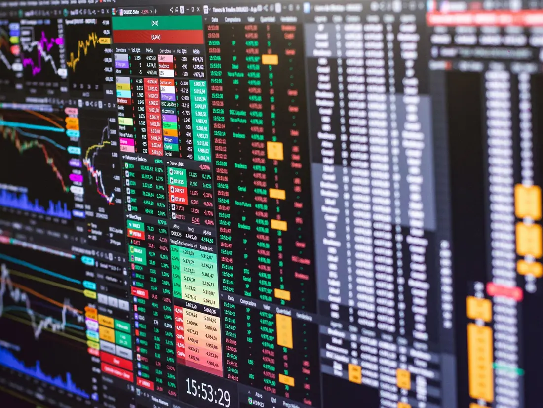 Graphique boursier de l'action Teleperformance sur un écran, avec bougies vertes et rouges.